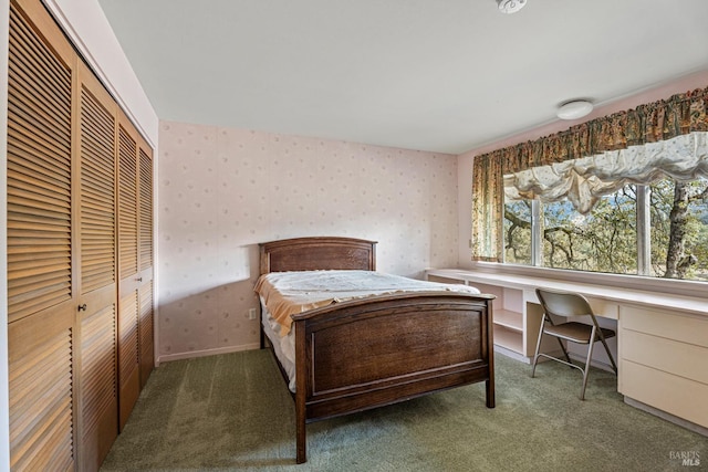 bedroom featuring dark colored carpet, built in desk, and a closet