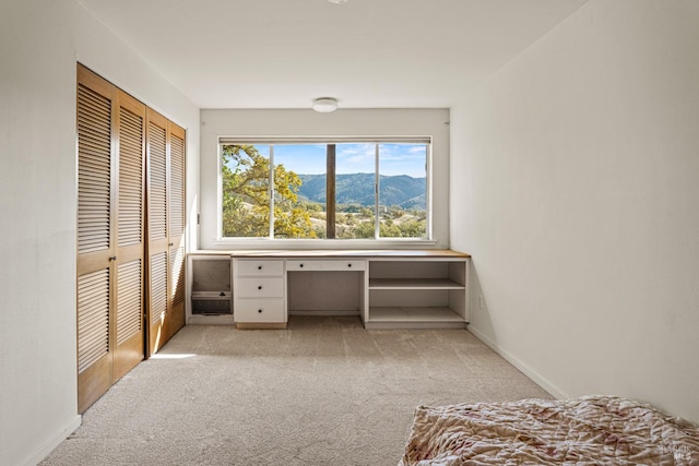 bedroom featuring a mountain view, light colored carpet, and a closet