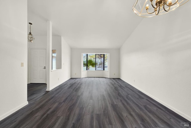 unfurnished living room featuring dark hardwood / wood-style flooring, an inviting chandelier, and lofted ceiling