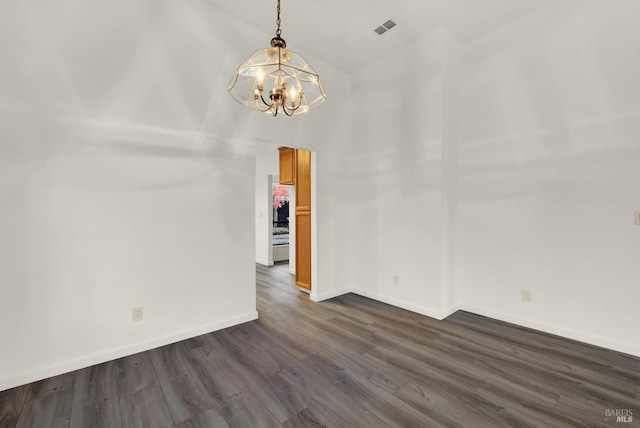 unfurnished room featuring a notable chandelier, dark hardwood / wood-style flooring, and lofted ceiling