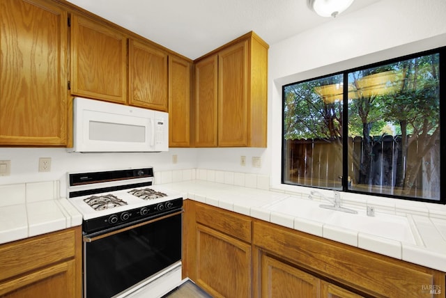 kitchen featuring tile countertops and white appliances