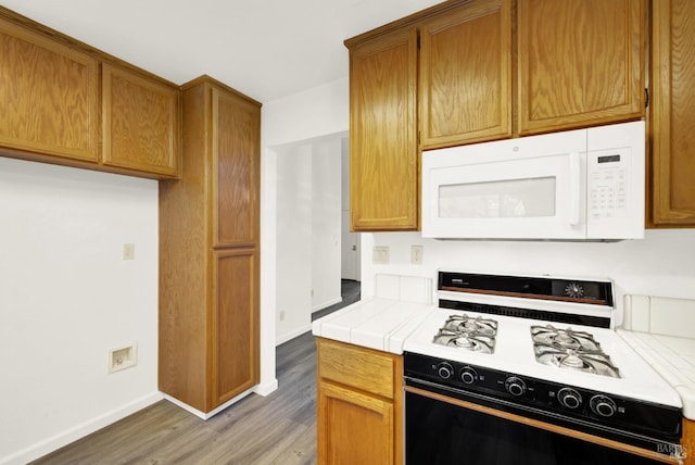 kitchen with tile countertops, dark wood-type flooring, and white appliances