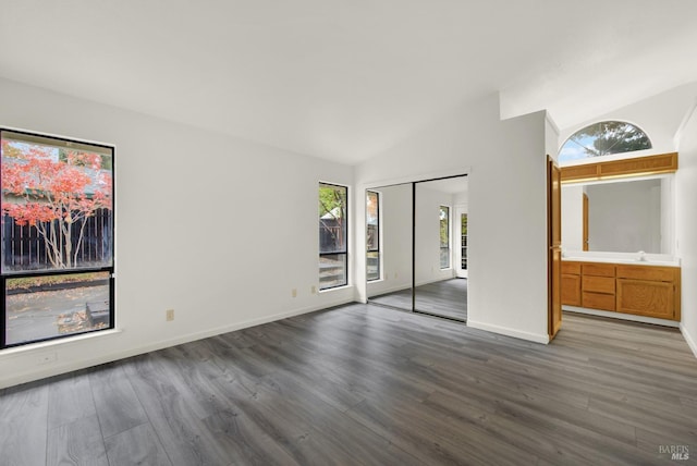 unfurnished bedroom with dark hardwood / wood-style flooring and lofted ceiling