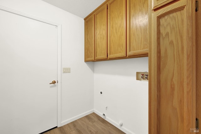 laundry room with electric dryer hookup, washer hookup, cabinets, and wood-type flooring