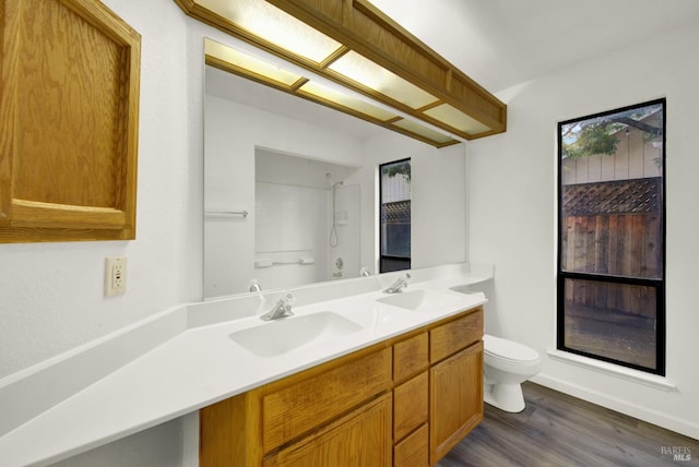 bathroom with a shower, toilet, vanity, and hardwood / wood-style flooring