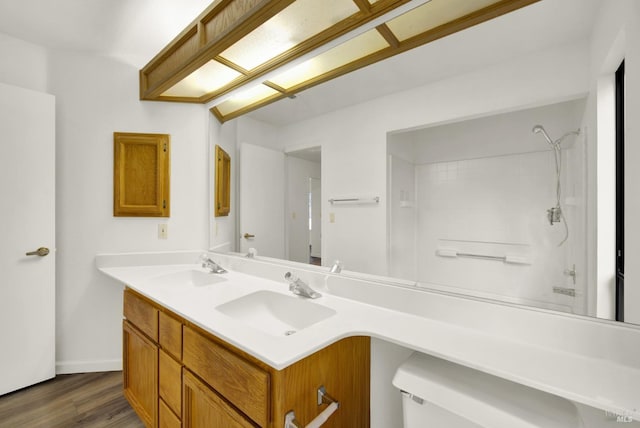 bathroom with hardwood / wood-style floors, vanity, toilet, and walk in shower