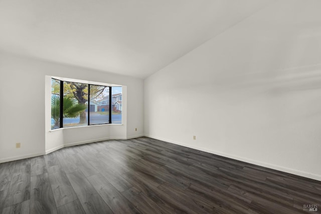 empty room with dark hardwood / wood-style floors and lofted ceiling