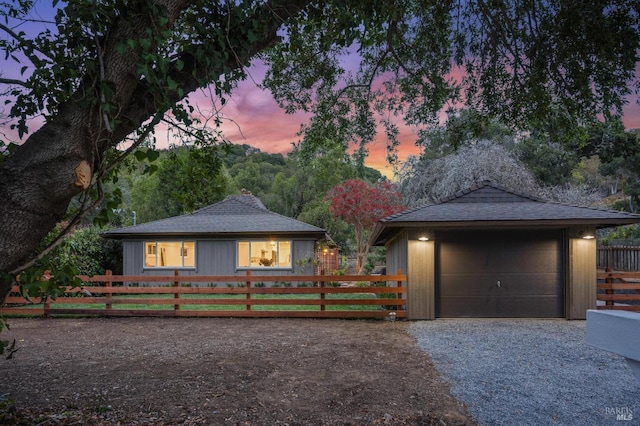 ranch-style home featuring a garage and an outbuilding