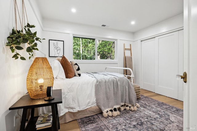 bedroom with light hardwood / wood-style flooring and a closet