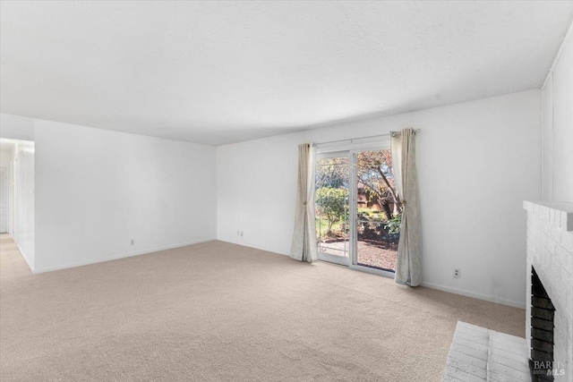 unfurnished living room featuring light carpet, a brick fireplace, and a textured ceiling