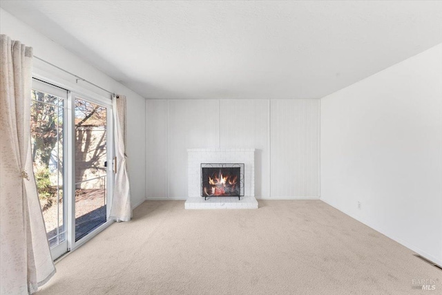 unfurnished living room featuring a fireplace and carpet flooring