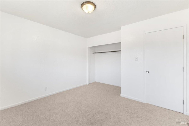 unfurnished bedroom with a closet and carpet flooring