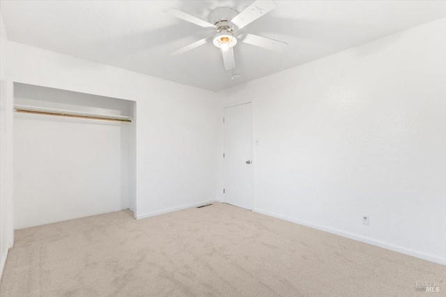 unfurnished bedroom featuring a closet, carpet, and ceiling fan