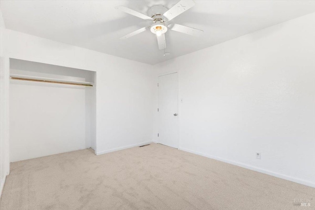 unfurnished bedroom featuring ceiling fan, a closet, and carpet floors