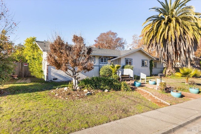 view of front of property featuring stucco siding, a front lawn, and fence