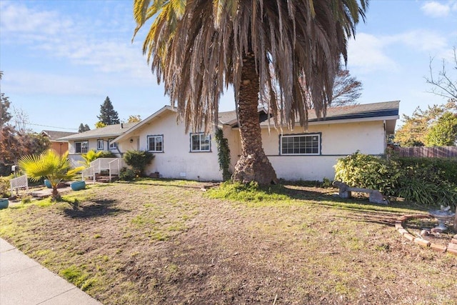 view of front of home with stucco siding and fence