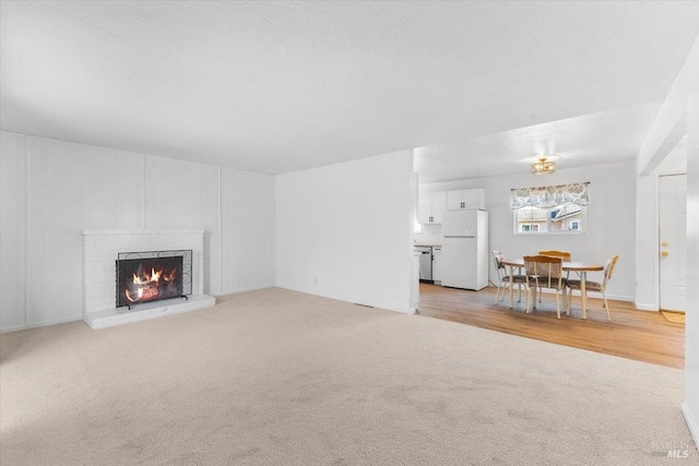 unfurnished living room featuring light carpet and a fireplace