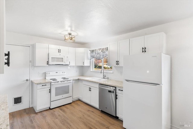 kitchen with a sink, white cabinets, visible vents, and white appliances