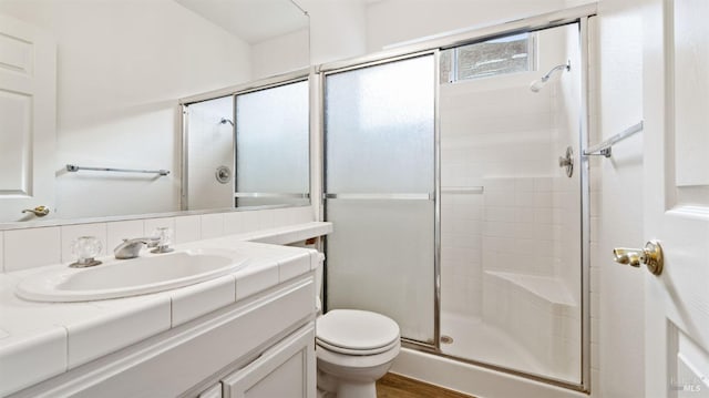 bathroom featuring vanity, wood-type flooring, an enclosed shower, and toilet