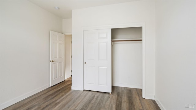 unfurnished bedroom featuring dark hardwood / wood-style floors and a closet