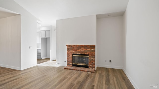 unfurnished living room featuring a fireplace and hardwood / wood-style flooring