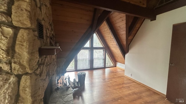 interior space featuring vaulted ceiling with beams, light hardwood / wood-style floors, and wooden ceiling