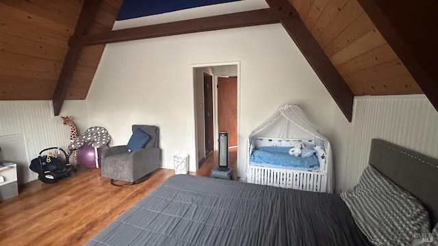 bedroom with wooden walls, hardwood / wood-style floors, lofted ceiling with beams, and wooden ceiling