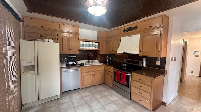 kitchen featuring light brown cabinets, sink, tasteful backsplash, custom range hood, and stainless steel appliances