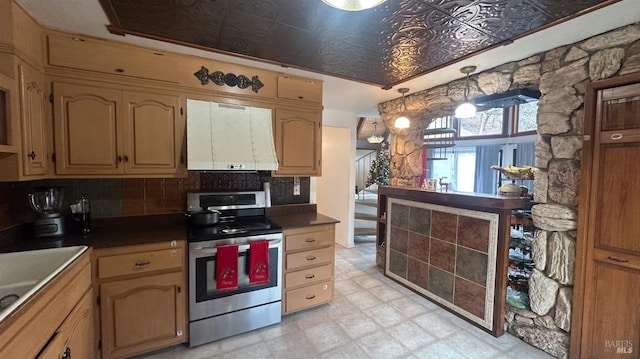 kitchen featuring stainless steel range with electric stovetop, custom exhaust hood, hanging light fixtures, and tasteful backsplash