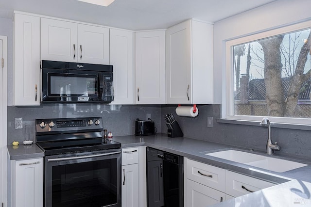 kitchen with black appliances, decorative backsplash, white cabinetry, and sink