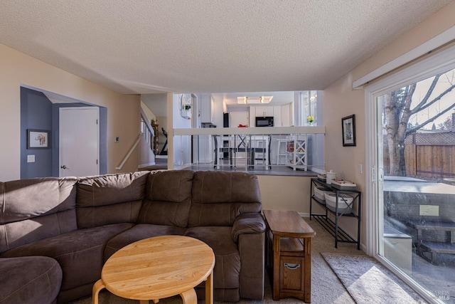 living room featuring light colored carpet and a textured ceiling