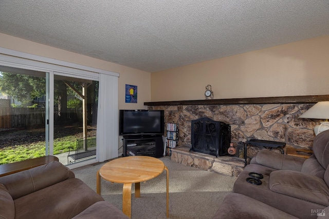 carpeted living room featuring a textured ceiling and a stone fireplace