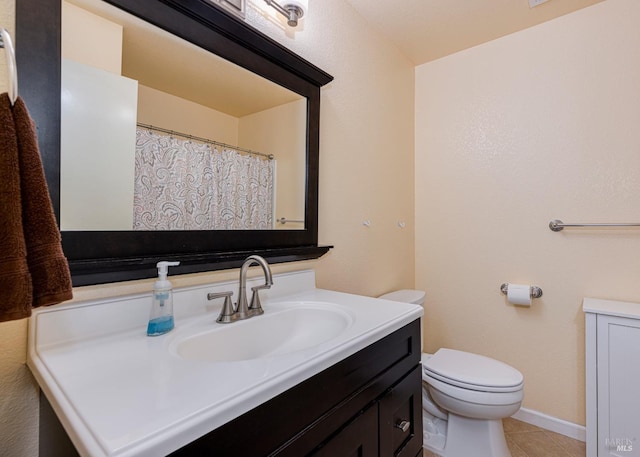 bathroom featuring tile patterned flooring, vanity, and toilet