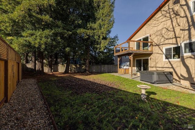 view of yard with a balcony, a patio, and a hot tub