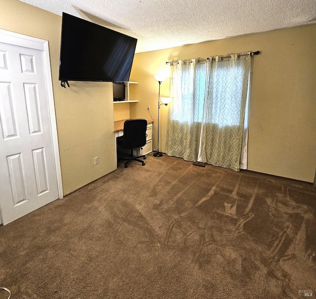 unfurnished office featuring a textured ceiling and carpet floors