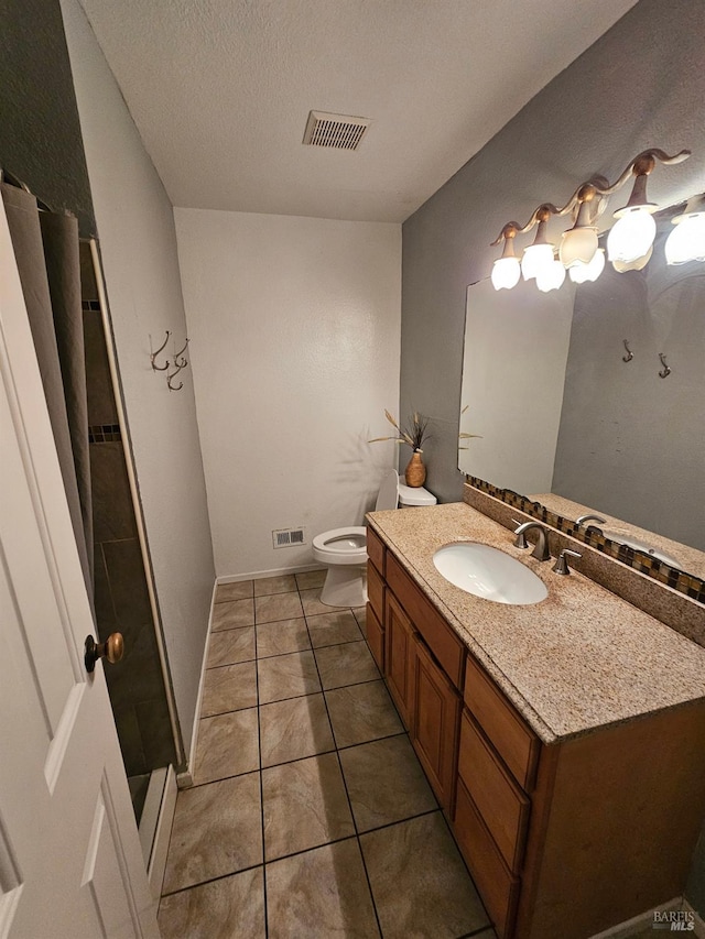 bathroom featuring tile patterned floors, vanity, a textured ceiling, a shower, and toilet