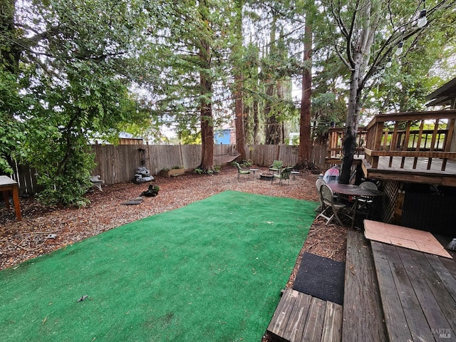 view of yard with a wooden deck and an outdoor fire pit