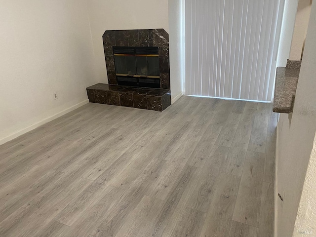 unfurnished living room with a fireplace and light hardwood / wood-style floors