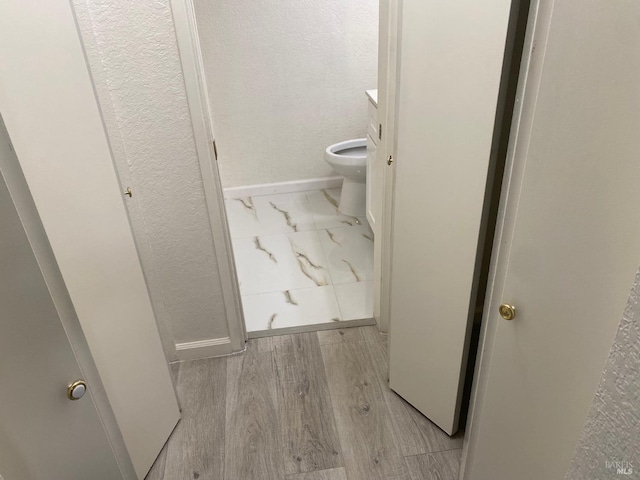 bathroom with wood-type flooring and toilet