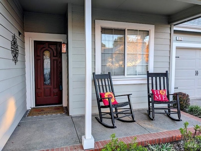 doorway to property with a garage and covered porch