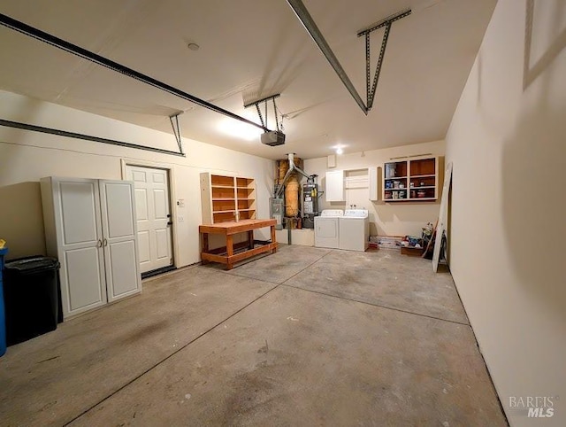 garage featuring a garage door opener, washer and clothes dryer, and water heater