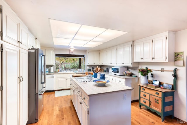 kitchen featuring a center island, high end refrigerator, white cabinets, and light hardwood / wood-style floors