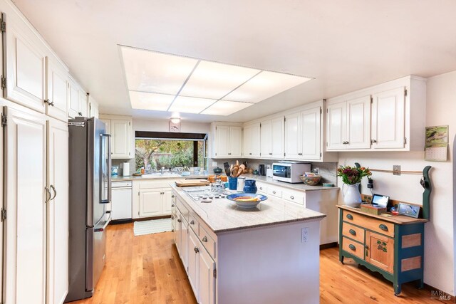 kitchen featuring a center island, high end refrigerator, white cabinets, and light hardwood / wood-style floors