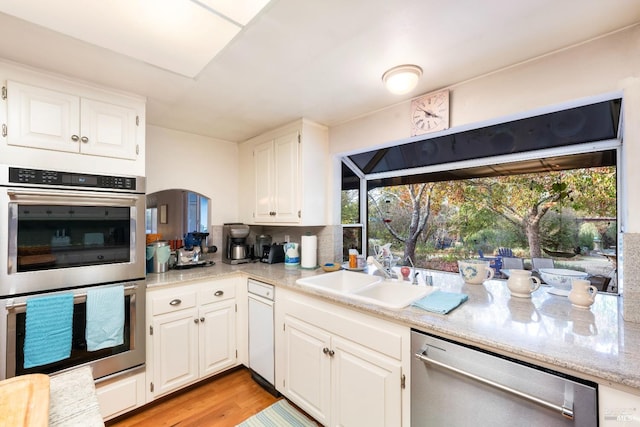 kitchen with stainless steel appliances, light hardwood / wood-style floors, sink, and white cabinets