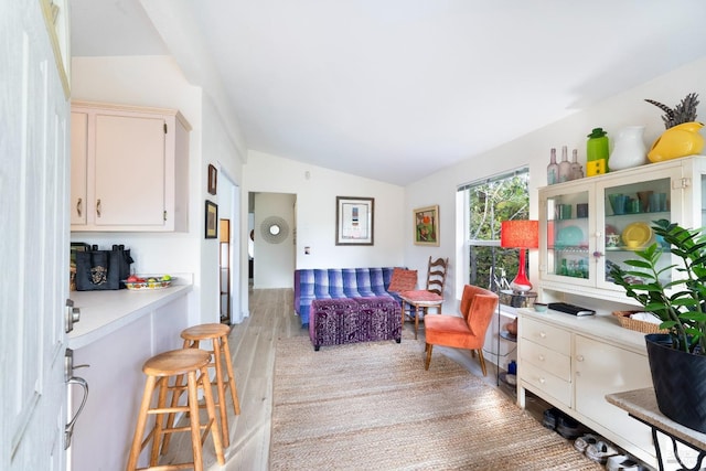 living area featuring lofted ceiling and light hardwood / wood-style floors