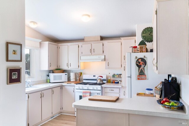 kitchen featuring white cabinetry, sink, white appliances, and light hardwood / wood-style flooring