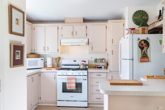 kitchen with white appliances and light hardwood / wood-style floors