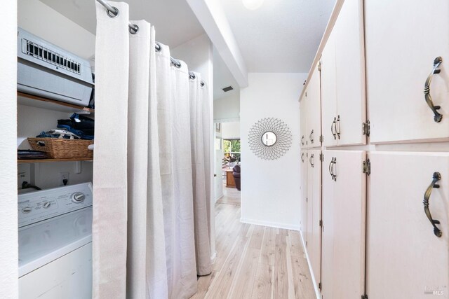 hall with visible vents, washer / dryer, and light wood-style flooring