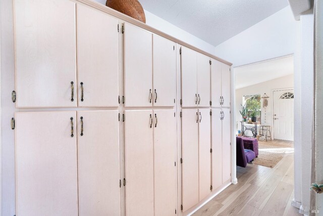 mudroom featuring lofted ceiling and light wood-type flooring