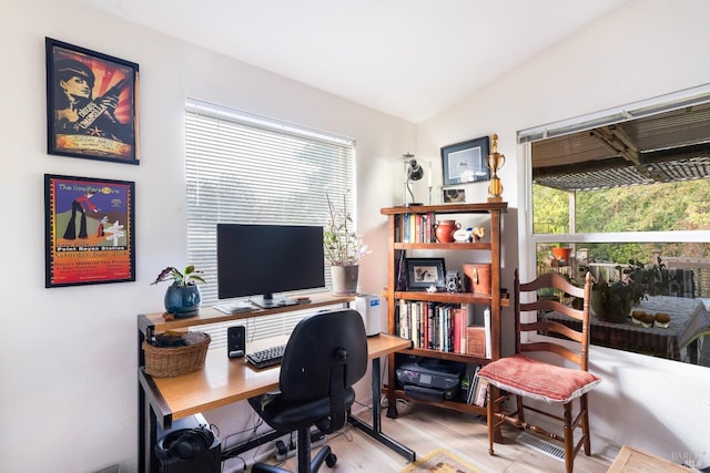 home office with vaulted ceiling, a wealth of natural light, and wood finished floors